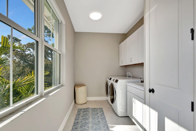 laundry room featuring cabinets, light tile patterned floors, and independent washer and dryer