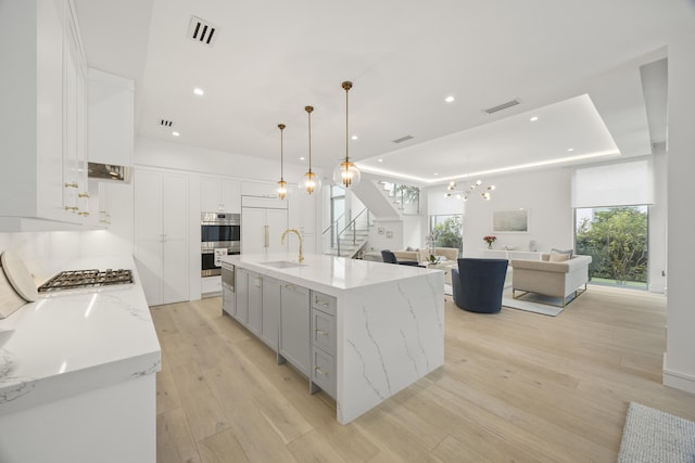 kitchen with white cabinets, appliances with stainless steel finishes, sink, and a large island