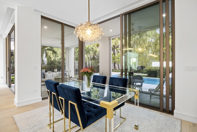 dining room with a wall of windows, an inviting chandelier, and hardwood / wood-style floors