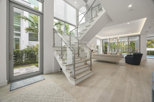 entrance foyer featuring plenty of natural light, a chandelier, and light wood-type flooring