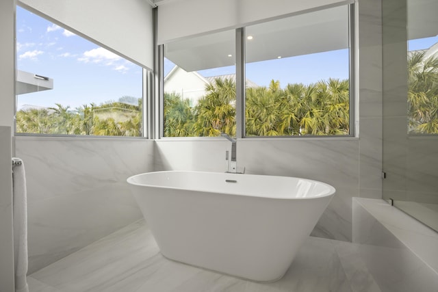 bathroom with a tub and plenty of natural light