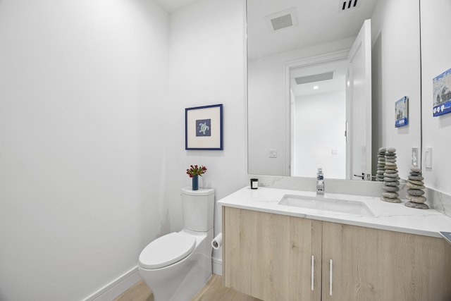 bathroom featuring toilet, hardwood / wood-style flooring, and vanity