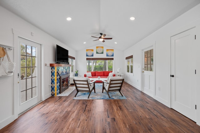 dining space with lofted ceiling, a fireplace, dark wood-type flooring, and ceiling fan