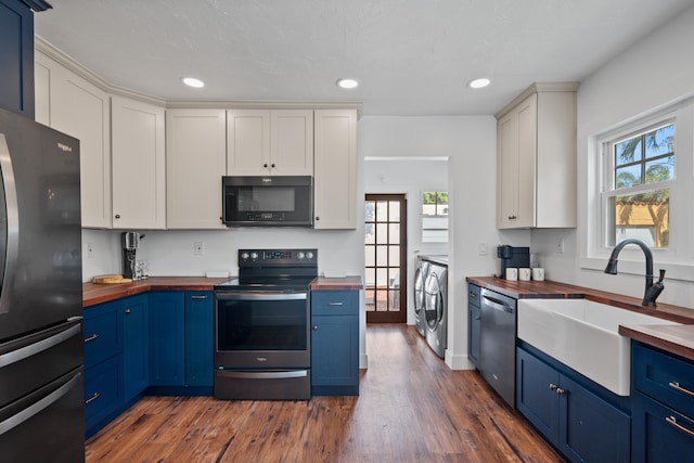 kitchen with stainless steel appliances, butcher block countertops, sink, and white cabinets