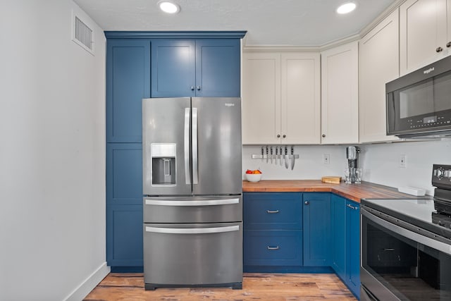 kitchen featuring appliances with stainless steel finishes, light hardwood / wood-style floors, blue cabinetry, wood counters, and white cabinets