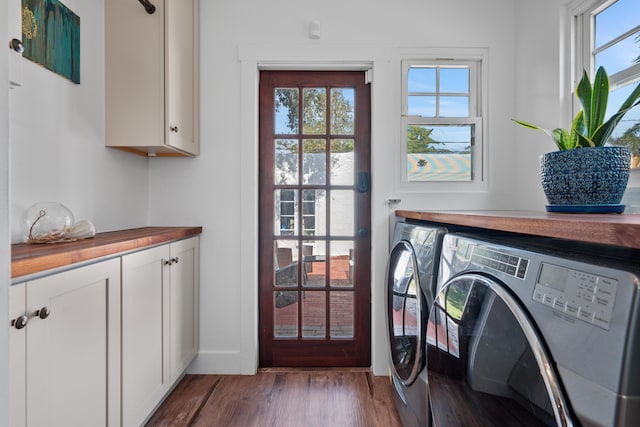 washroom with separate washer and dryer, cabinets, and hardwood / wood-style flooring