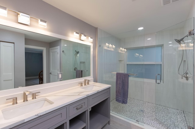 bathroom featuring vanity and a shower with shower door