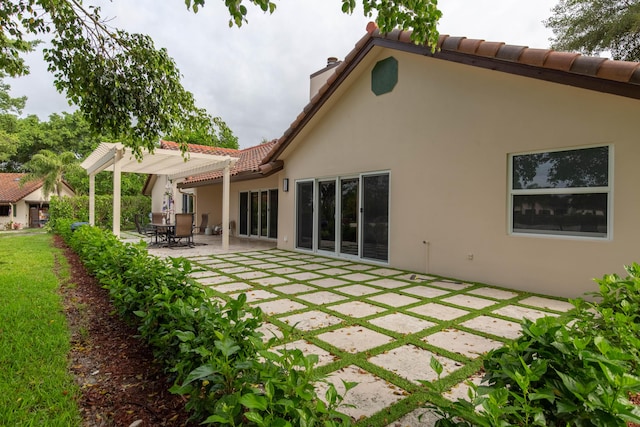 back of property with a pergola and a patio