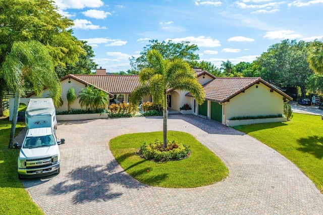 mediterranean / spanish home with a garage and a front lawn