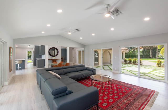 living room with light hardwood / wood-style floors, vaulted ceiling, and ceiling fan