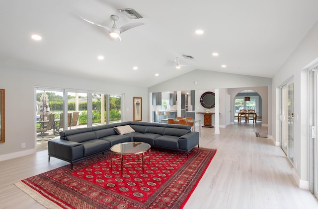 living room with ceiling fan, light wood-type flooring, and vaulted ceiling