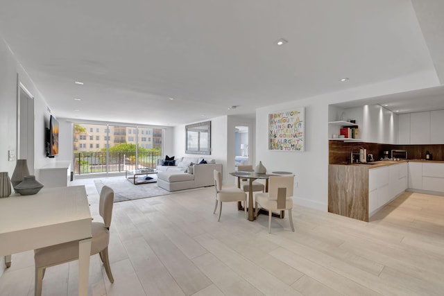 dining room featuring expansive windows, light hardwood / wood-style floors, and sink