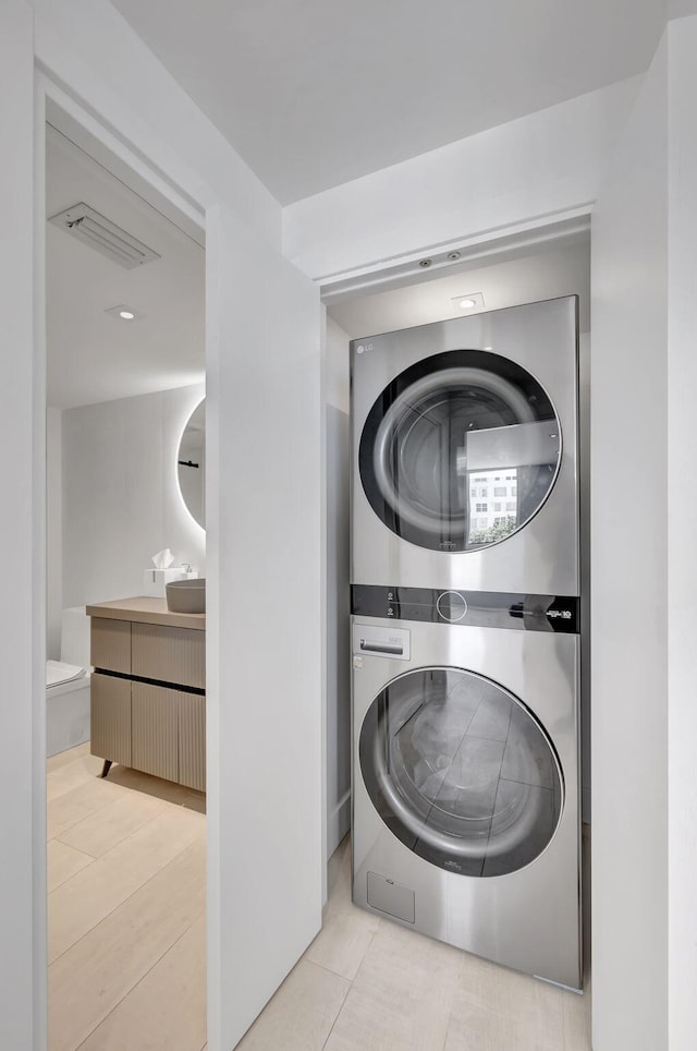 3456 S Ocean Blvd Unit 2060, Palm Beach, FL 33480 - laundry area featuring stacked washing machine and dryer and tile patterned flooring