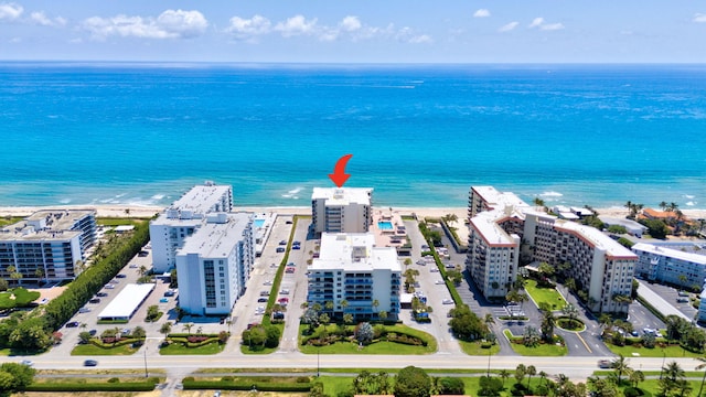 bird's eye view featuring a water view and a beach view