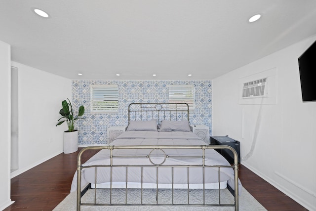 bedroom with wood-type flooring and a wall mounted AC