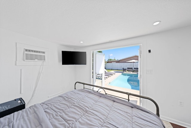 unfurnished bedroom featuring a textured ceiling, access to outside, and an AC wall unit