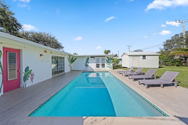 view of pool with a patio area and a shed