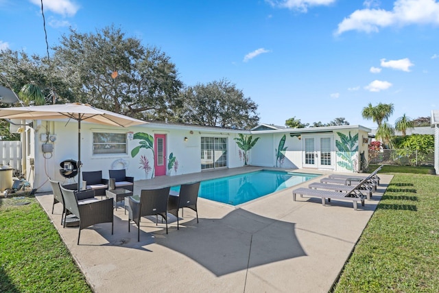 view of pool with a lawn, a patio, and french doors