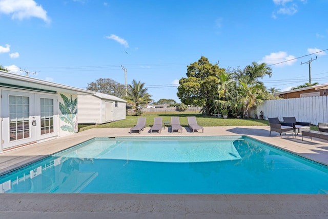 view of pool with a lawn, a patio area, and french doors