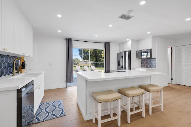 kitchen featuring decorative backsplash, a center island, and appliances with stainless steel finishes