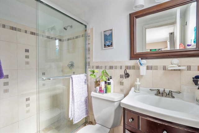 bathroom with tile walls, walk in shower, vanity, and toilet