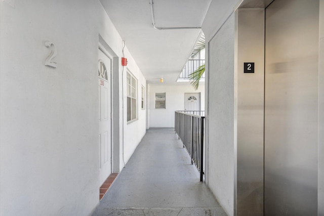 hall with elevator and concrete floors