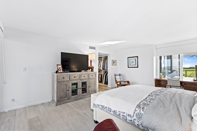 bedroom featuring a closet, light wood-type flooring, and a spacious closet