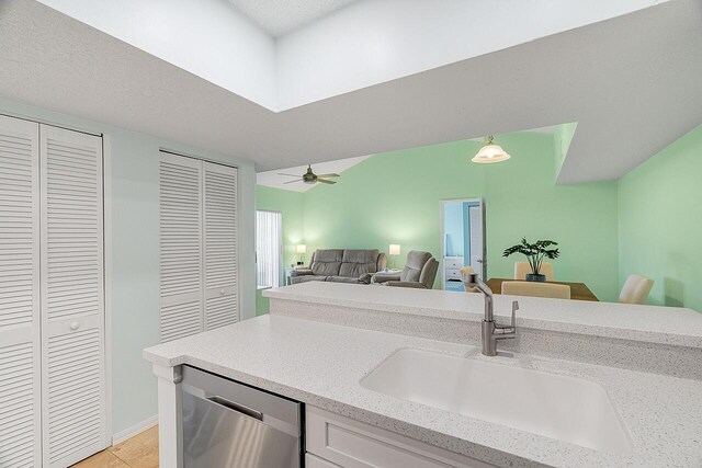 kitchen featuring white cabinetry, sink, kitchen peninsula, light tile patterned floors, and appliances with stainless steel finishes