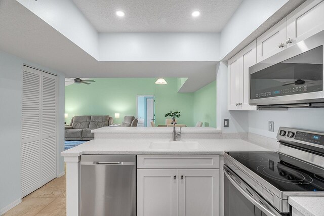 kitchen featuring ceiling fan, dishwasher, sink, decorative light fixtures, and light tile patterned flooring