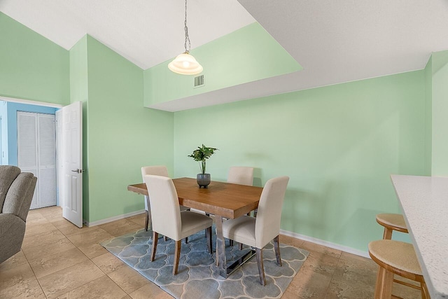 dining space featuring vaulted ceiling