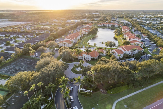 aerial view at dusk featuring a water view