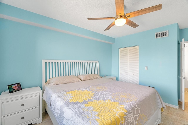 bedroom with ceiling fan, a textured ceiling, and a closet