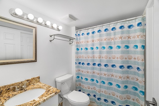 bathroom featuring vanity, toilet, and curtained shower