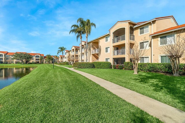 surrounding community with a yard and a water view