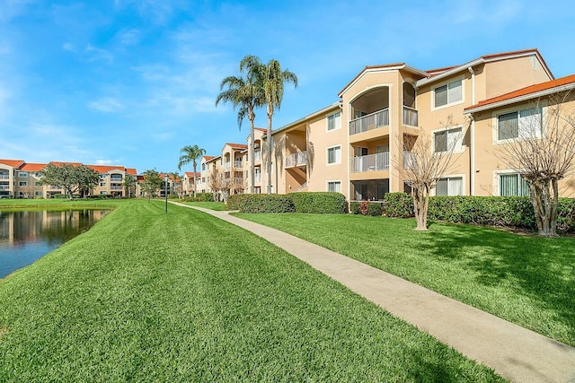 view of property's community with a yard and a water view