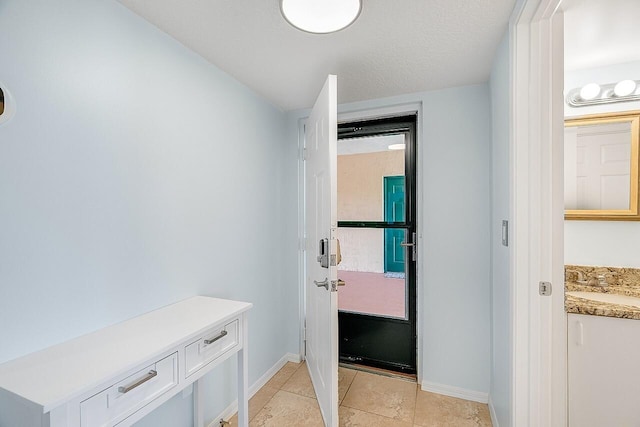 interior space with sink, light tile patterned floors, and a textured ceiling