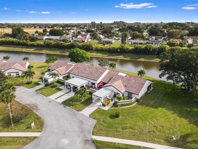 single story home featuring stucco siding, driveway, a tile roof, and a front lawn