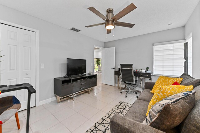 home office featuring a textured ceiling, ceiling fan, light tile patterned floors, and sink