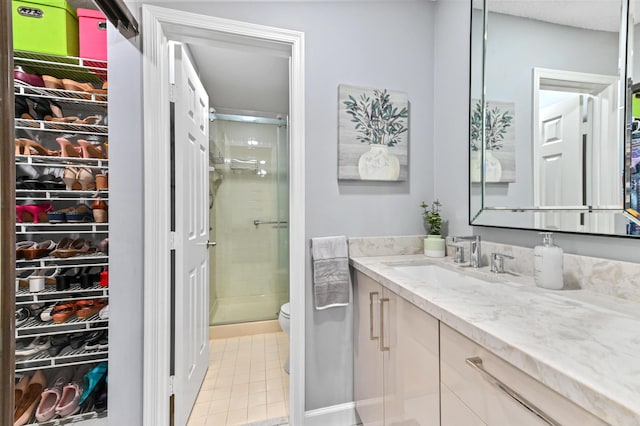 5650 Parkwalk Cir E, Boynton Beach, FL 33472 - full bathroom with tile patterned flooring, vanity, a walk in closet, toilet, and a stall shower