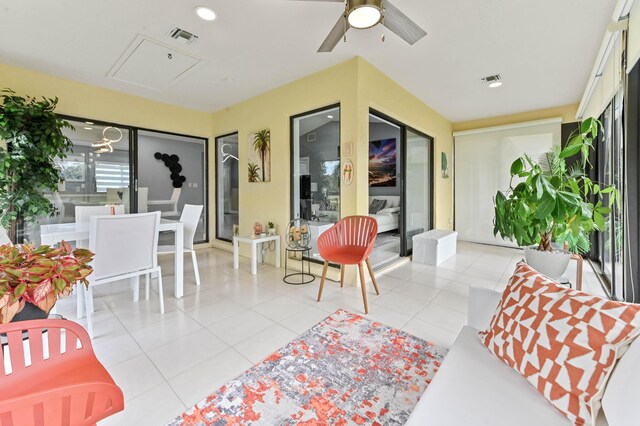 sunroom featuring ceiling fan and a water view