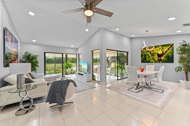 tiled living room featuring a textured ceiling, ceiling fan, and high vaulted ceiling