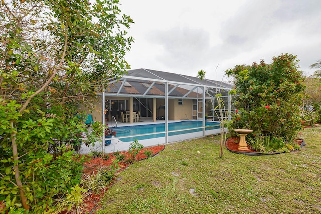 view of swimming pool featuring a lanai, a yard, and a patio