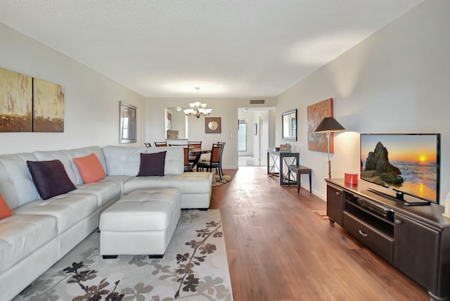 living room featuring a notable chandelier, a textured ceiling, and wood-type flooring