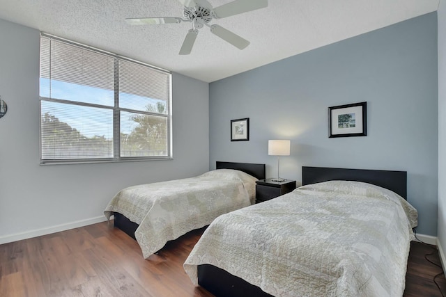 bedroom featuring dark hardwood / wood-style flooring, a textured ceiling, and ceiling fan