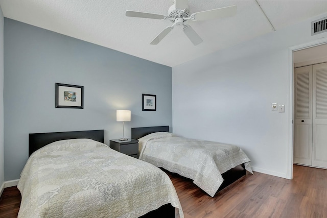 bedroom featuring dark wood-type flooring, ceiling fan, and a closet