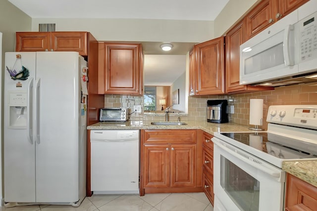 kitchen featuring white appliances, light stone countertops, light tile patterned floors, sink, and tasteful backsplash