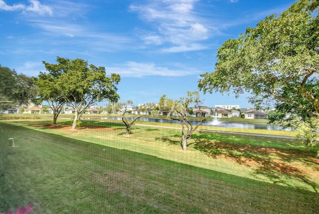 view of property's community with a lawn and a water view