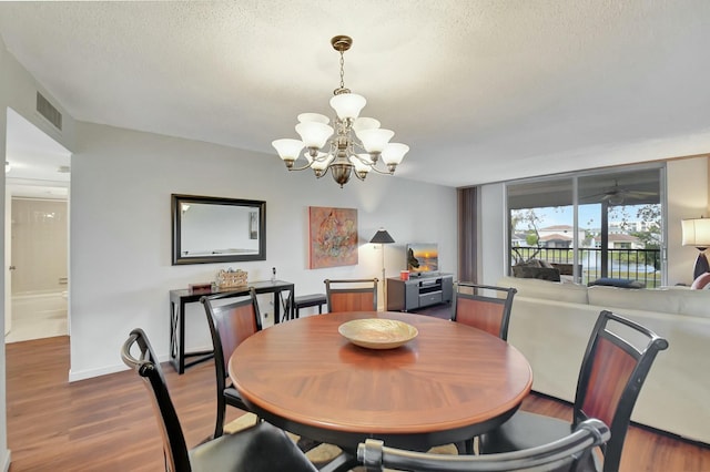 dining space featuring a textured ceiling, a chandelier, and hardwood / wood-style floors