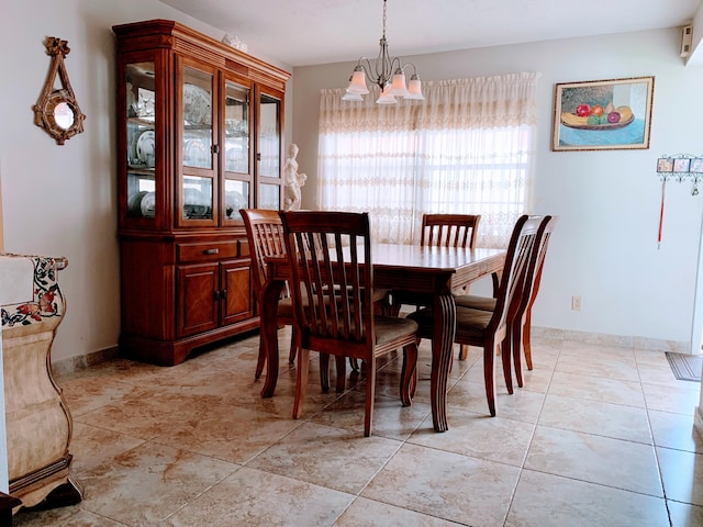 dining space with light tile patterned flooring and a chandelier