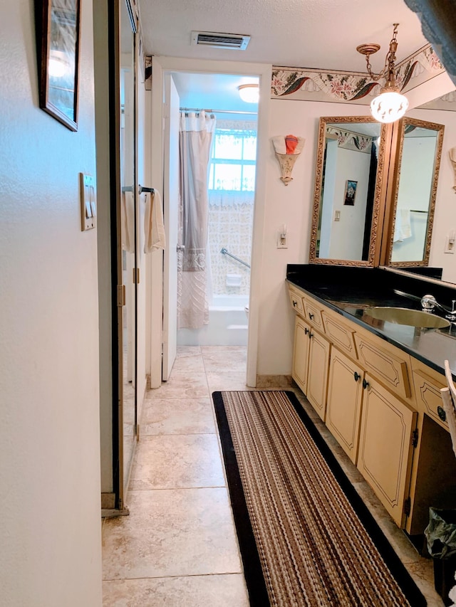 bathroom featuring shower / bathtub combination with curtain, vanity, and tile patterned flooring